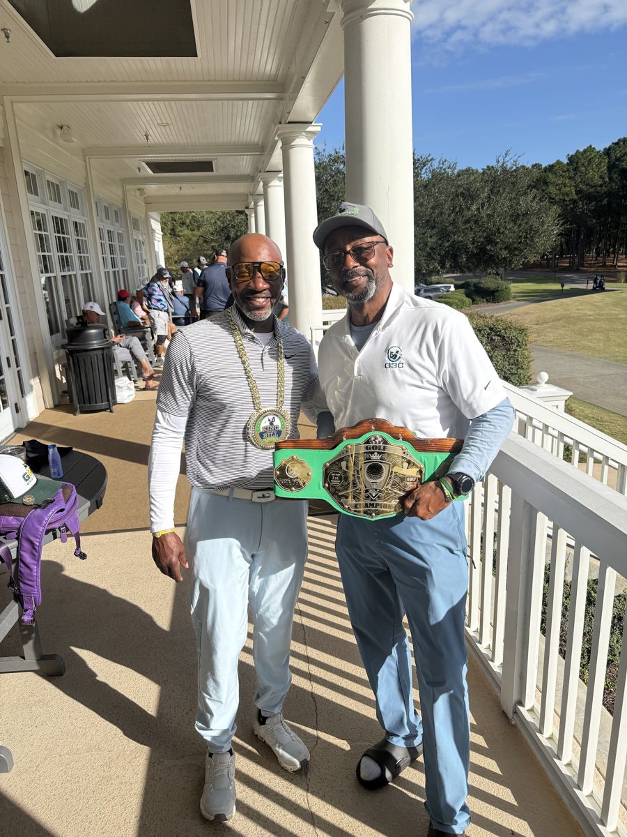 Kaleth Wright wearing the King of the Hill chain beside Cliff Price holding the champion's belt on the clubhouse porch